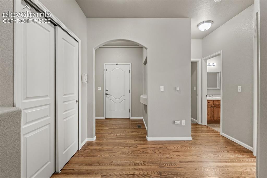 Image 2 of 20: Entryway featuring wood-finish flooring, a decorative arched interior doorw