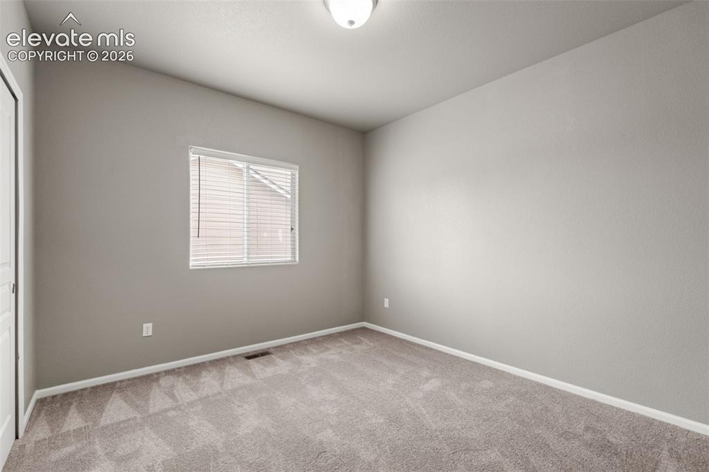 Image 8 of 20: Neutral-toned interior space featuring textured wall-to-wall carpeting, a s