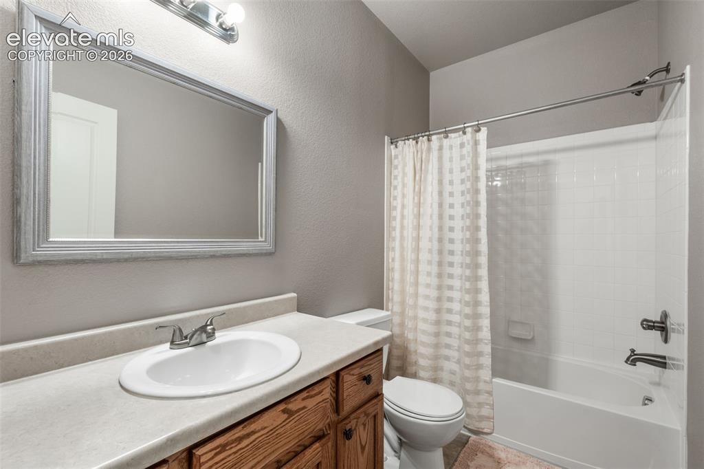 Image 9 of 20: Bathroom featuring a wood vanity with a solid-surface countertop, integrate