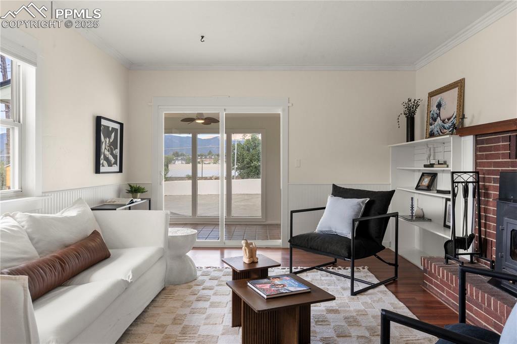 Image 12 of 30: Living area featuring wood finished floors, wainscoting, and ornamental mol
