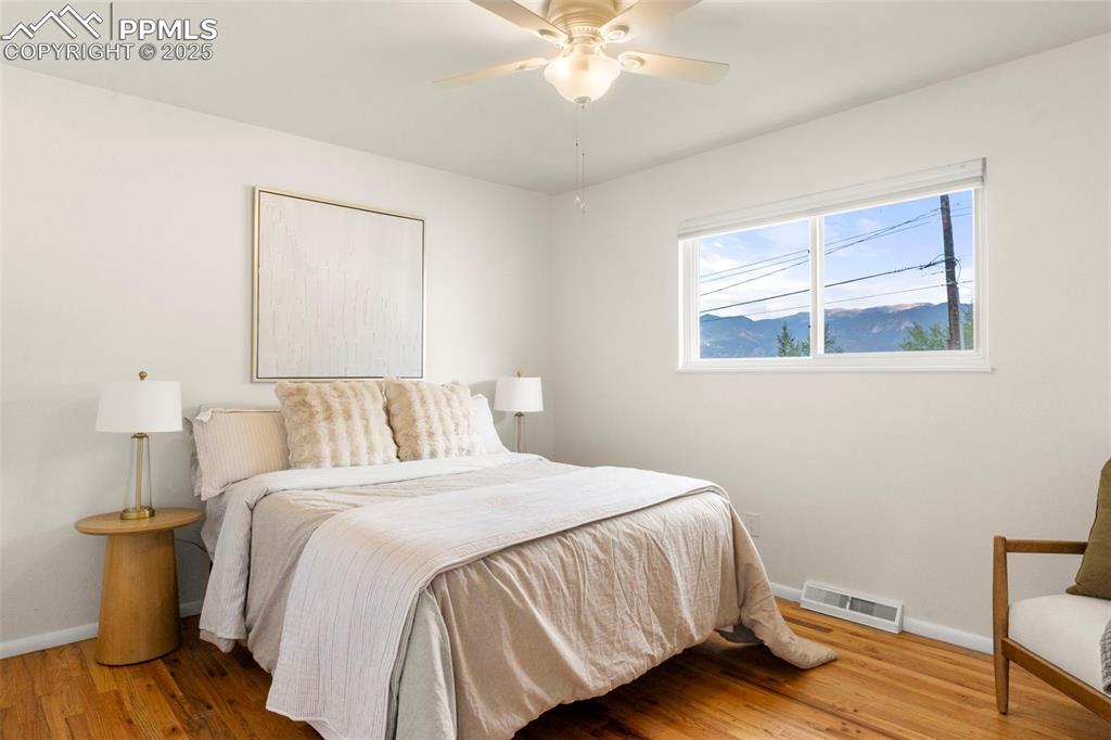 Image 14 of 30: Bedroom with wood finished floors and ceiling fan
