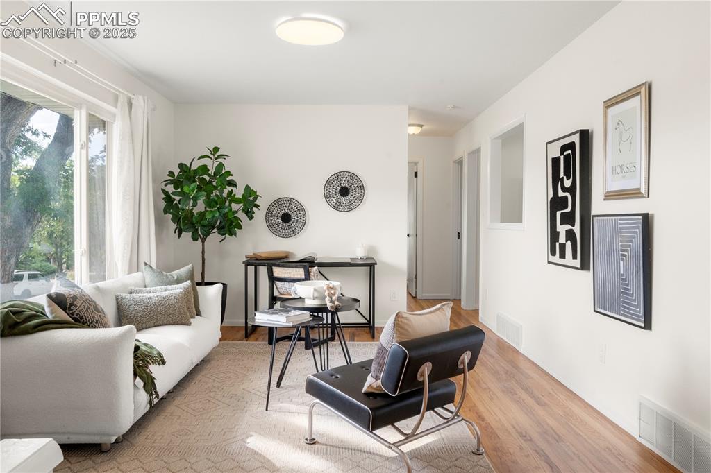 Image 2 of 30: Living area featuring light wood-style floors