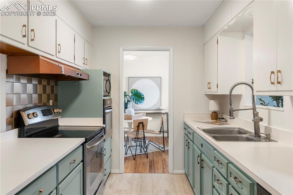 Image 9 of 30: Kitchen featuring appliances with stainless steel finishes, light counterto