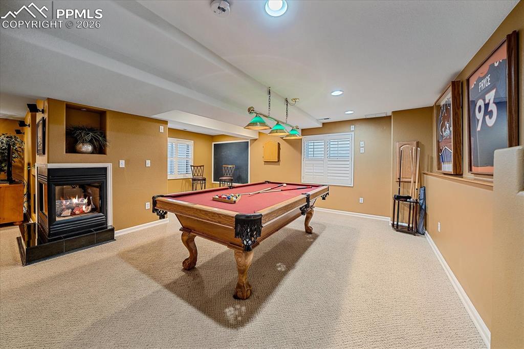 Image 30 of 50: Basement with fireplace and bonus/recreation area