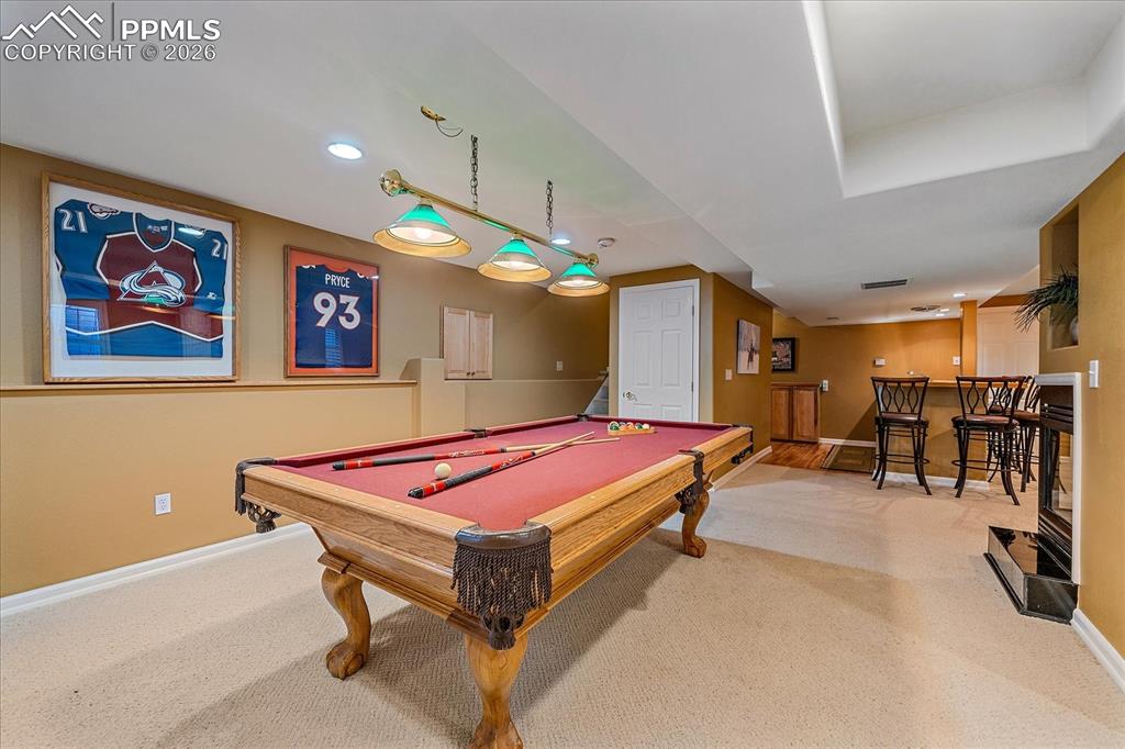 Image 31 of 50: Basement with fireplace and bonus/recreation area, wet bar