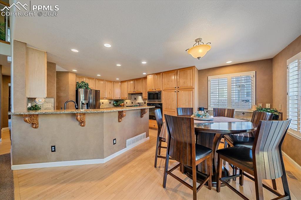 Image 8 of 50: Kitchen with Gourmet Kitchen, Granite Countertops, Breakfast Nook, Wood Flo
