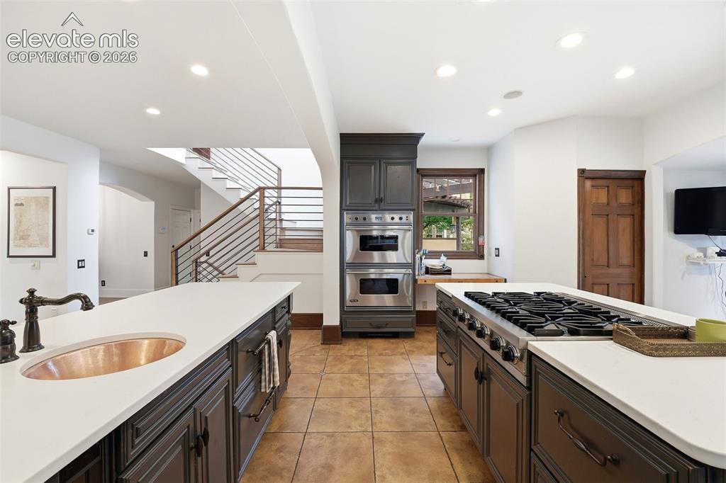 Image 12 of 50: Gourmet kitchen with double islands, stainless steel gas range, built-in do