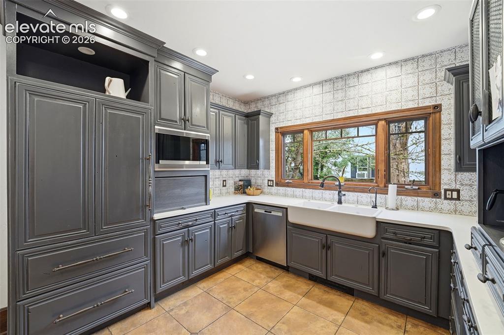 Image 14 of 50: Kitchen featuring floor-to-ceiling cabinetry, integrated stainless steel ap