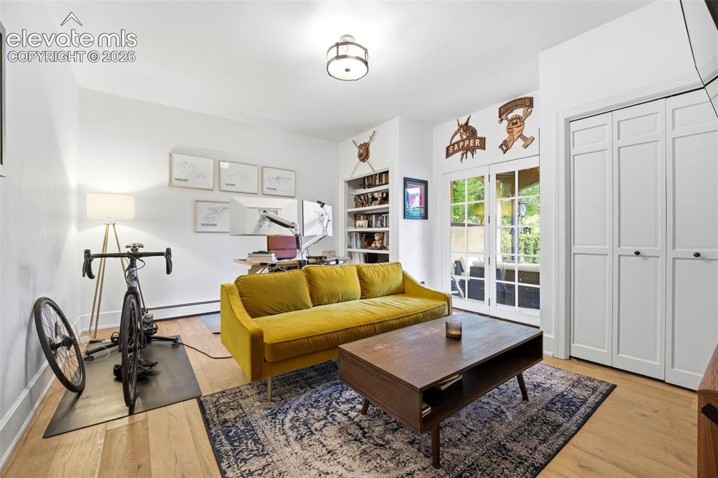 Image 17 of 50: Main level bedroom currently used as an office with walk out to back deck