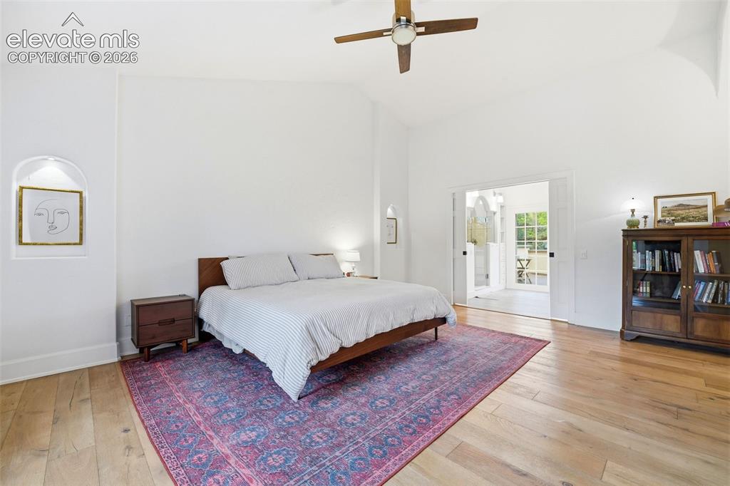 Image 19 of 50: High vaulted ceiling with a ceiling fan, light wood-finish flooring, built-
