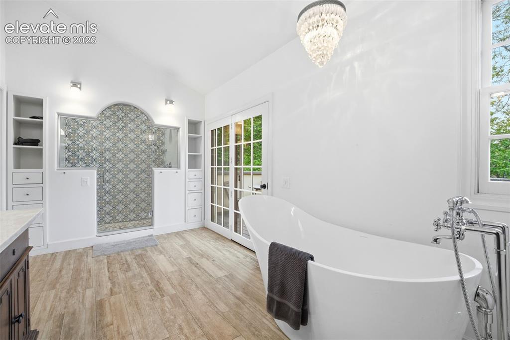 Image 20 of 50: Spacious bathroom featuring a freestanding soaking tub with floor-mounted f