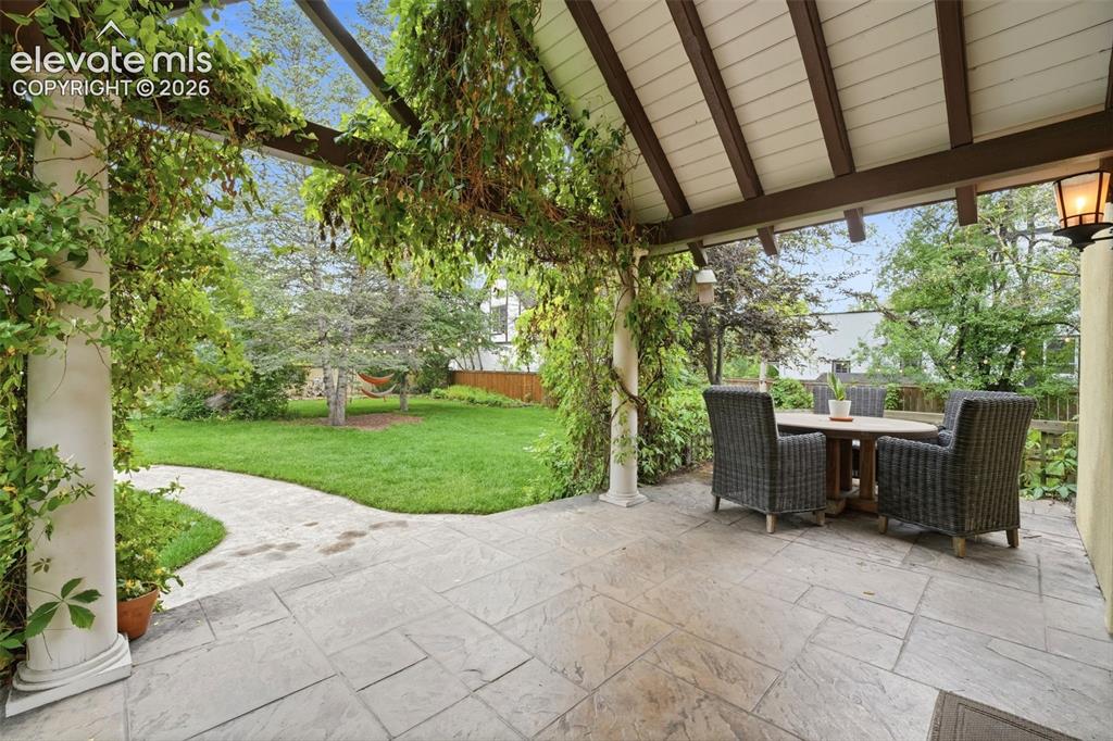 Image 41 of 50: Incredible and expansive back patio, with lunch gardens and mature trees 