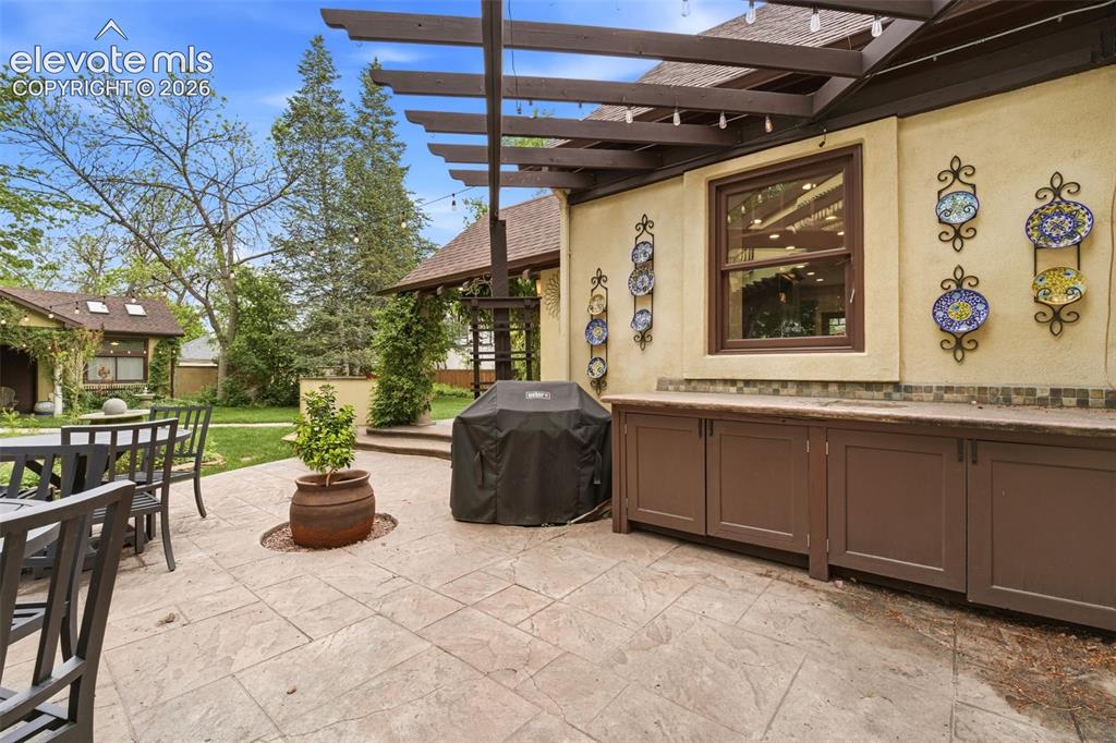 Image 43 of 50: Outdoor entertaining area featuring a stamped concrete patio, built-in cabi