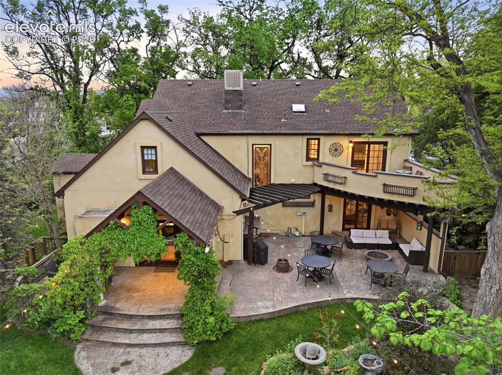 Image 46 of 50: Expansive stucco exterior featuring a multi-level patio, a covered outdoor 