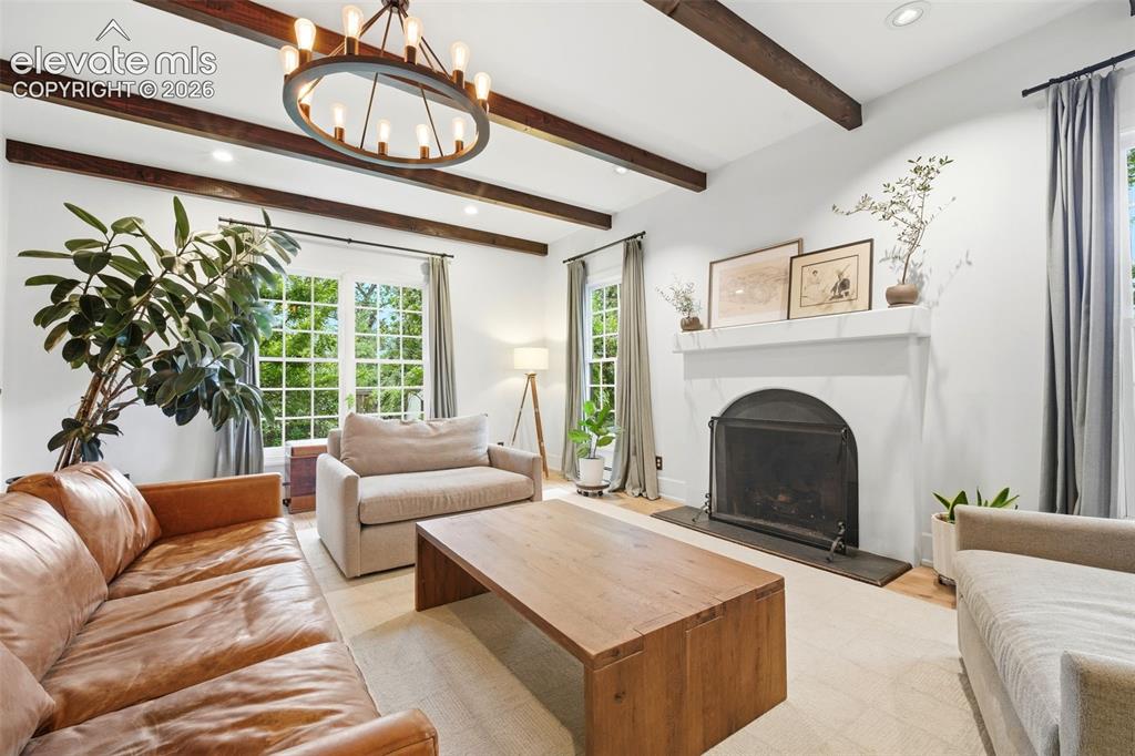 Image 6 of 50: Inviting fireplace with exposed beams and fireplace