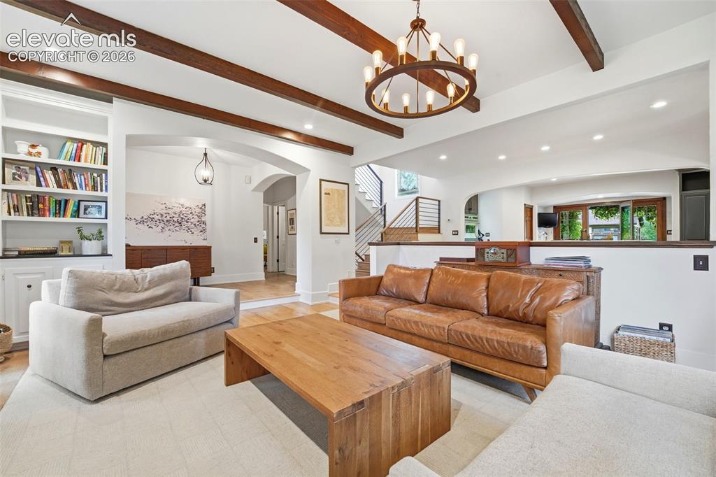 Image 7 of 50: Living area featuring exposed ceiling beams, recessed lighting, a built-in 