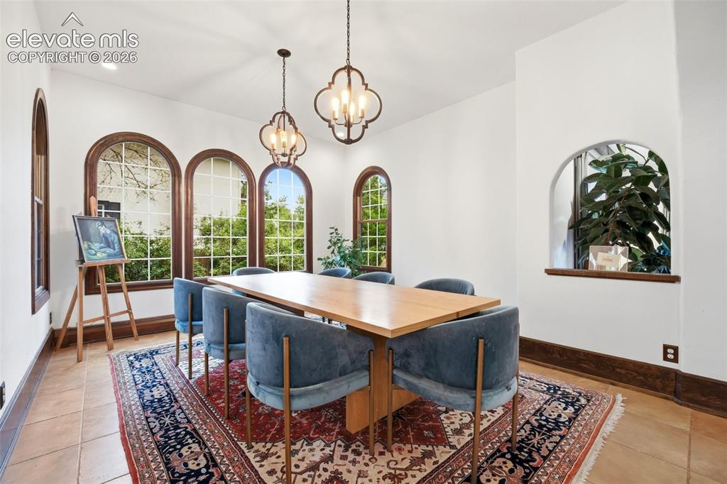 Image 9 of 50: Interior space featuring arched windows with dark wood trim, recessed ceili