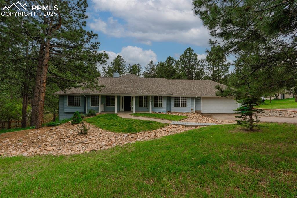 Caption: Ranch-style home featuring a front yard, concrete driveway, a chimney, roof with shingles, and a gar