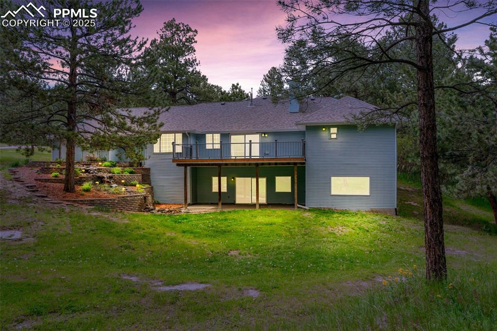 Image 10 of 31: Back of property featuring a patio area and a lawn