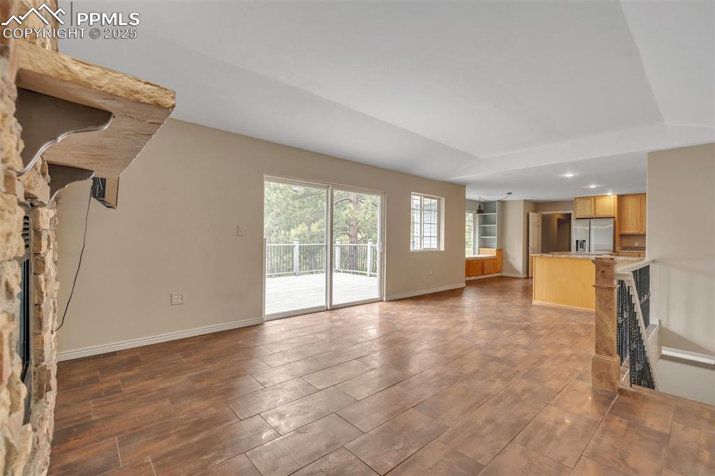 Image 19 of 31: Unfurnished living room with wood tiled floors and baseboards
