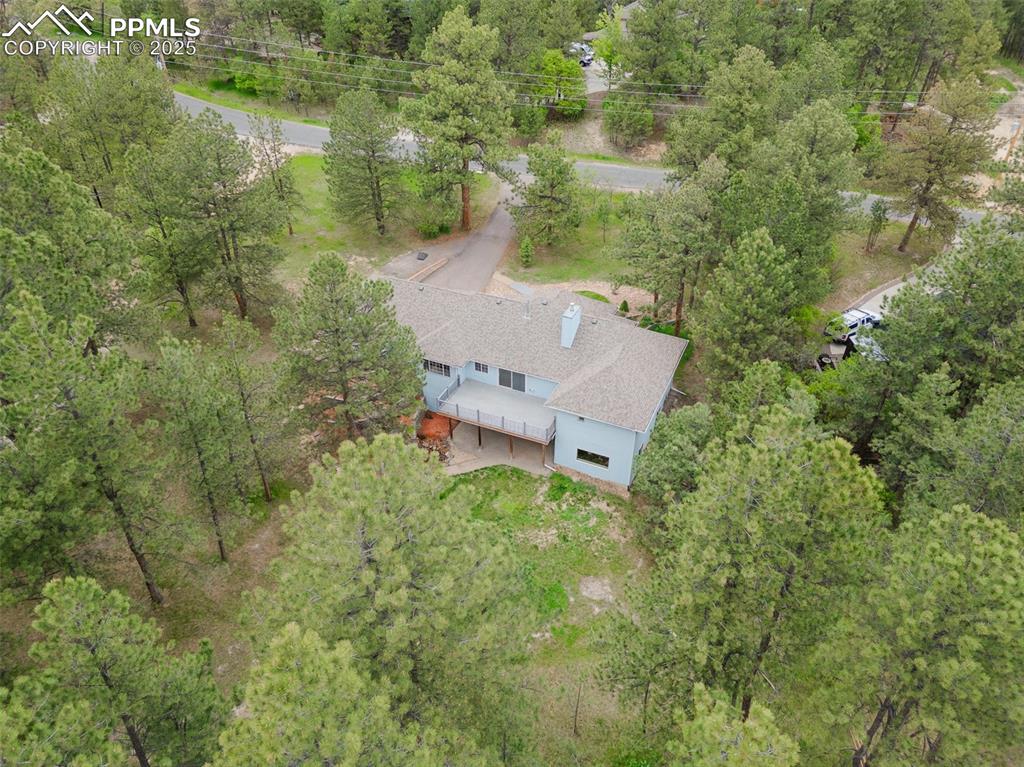 Image 7 of 31: View from above of property featuring a tree filled landscape