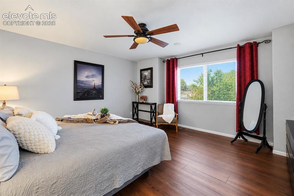 Image 16 of 50: Natural light, warm flooring and ample room give the primary bedroom an eas