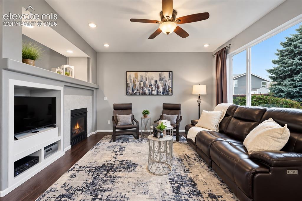 Image 28 of 50: Large windows fill the family room with natural light while the second fire