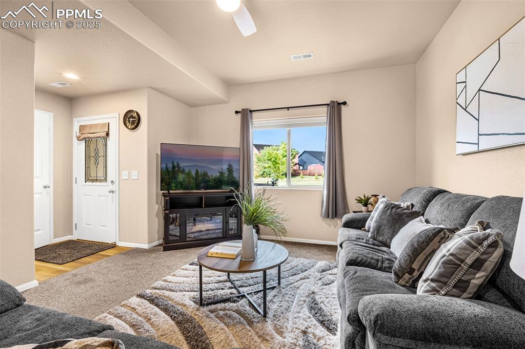 Image 13 of 34: Living area with baseboards and a ceiling fan