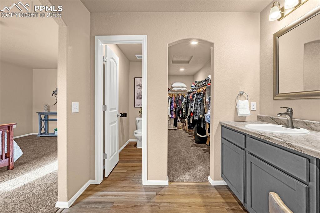 Image 19 of 34: Bathroom featuring toilet, vanity, wood finished floors, and baseboards