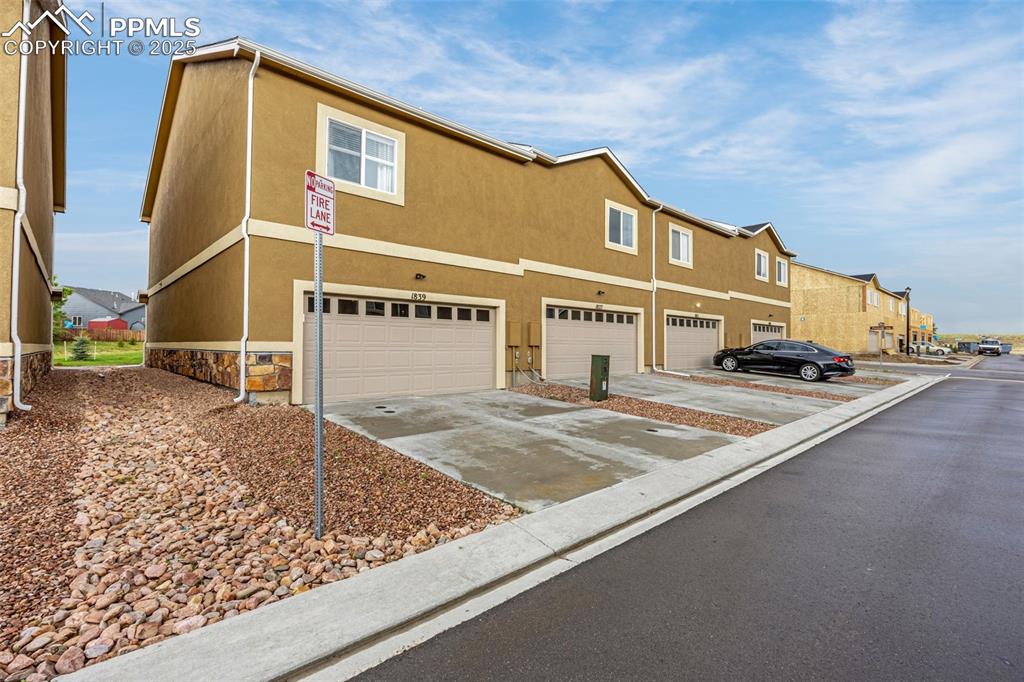 Image 28 of 34: View of front facade with an attached garage, concrete driveway, stucco sid