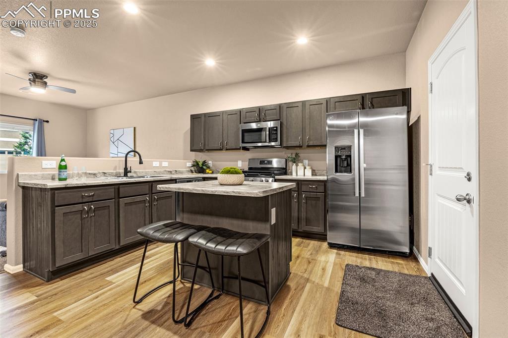 Image 3 of 34: Kitchen with stainless steel appliances, light wood-style flooring, a kitch