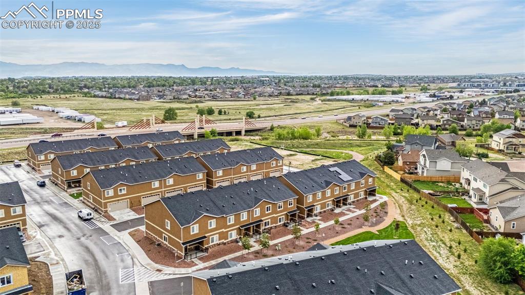 Image 32 of 34: Aerial perspective of suburban area with a mountain backdrop