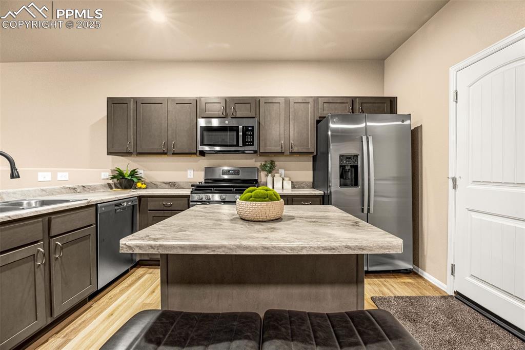 Image 4 of 34: Kitchen featuring stainless steel appliances, a sink, light countertops, li