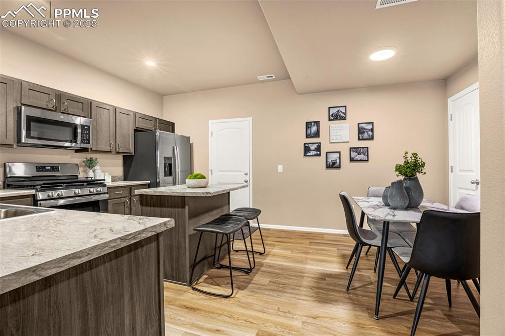 Image 7 of 34: Kitchen featuring stainless steel appliances, a kitchen island, a breakfast