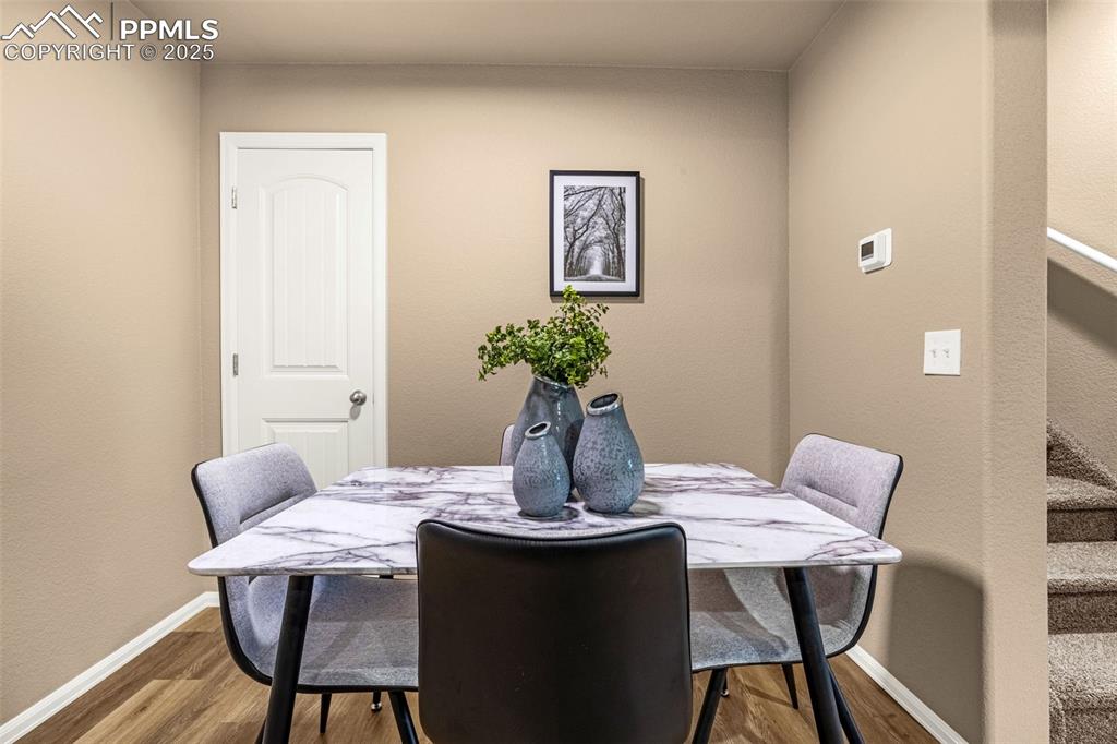 Image 8 of 34: Dining room featuring wood finished floors, baseboards, and stairway