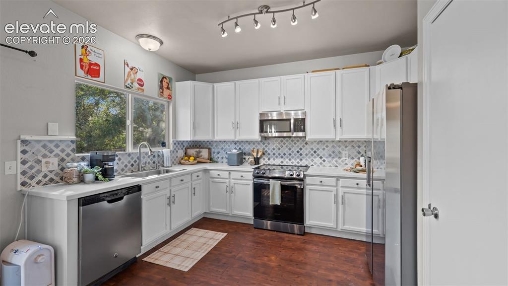 Image 10 of 26: Kitchen with white cabinetry, stainless steel appliances, a patterned tile
