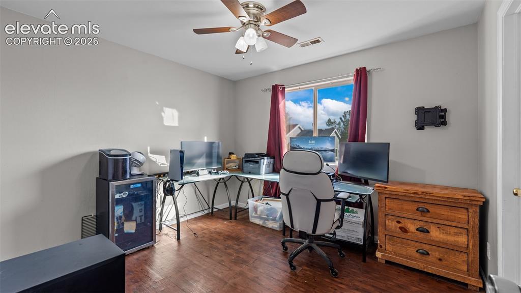 Image 14 of 26: Wood-finish flooring, ceiling fan with integrated lighting, and a window pr