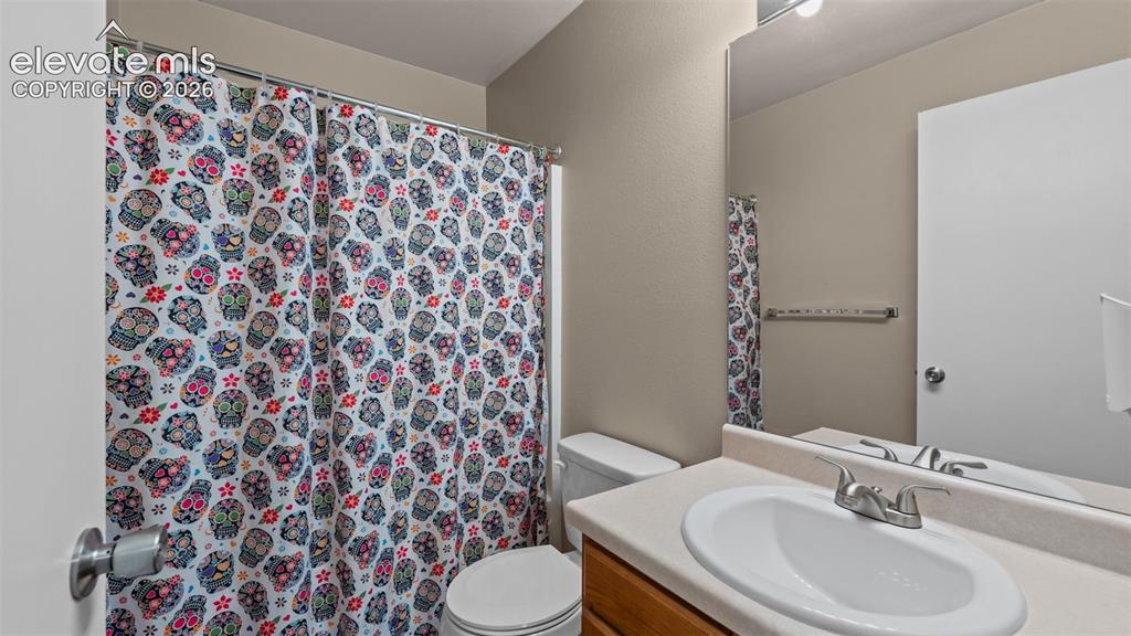 Image 15 of 26: Bathroom featuring a vanity with an integrated sink, wood-finish cabinetry,