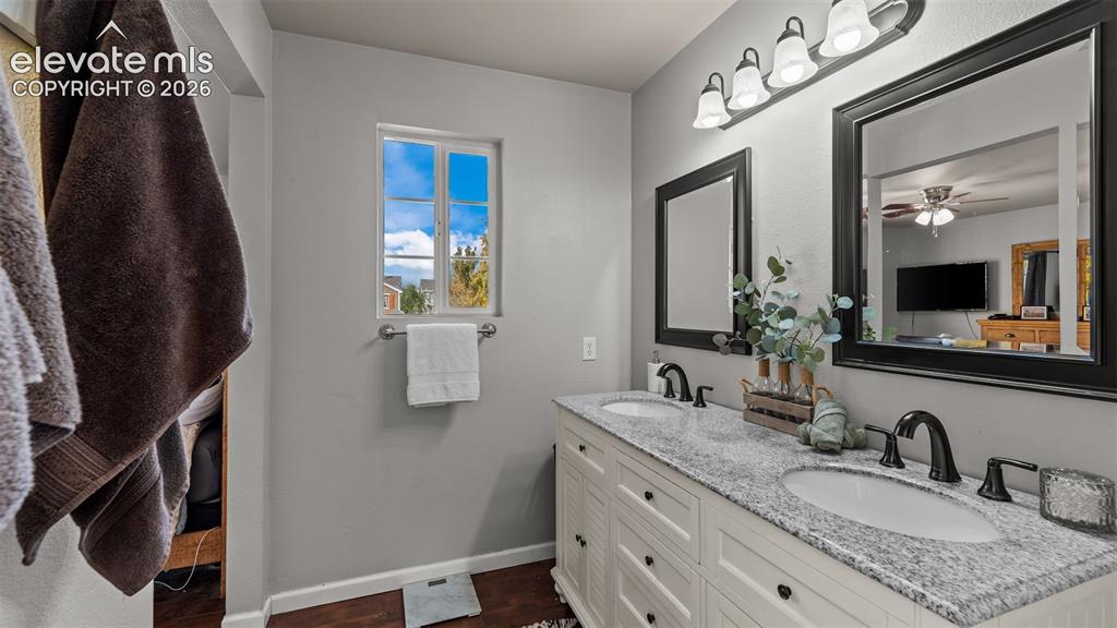 Image 20 of 26: Double vanity with granite-style countertop, dual sinks, and matte black fi