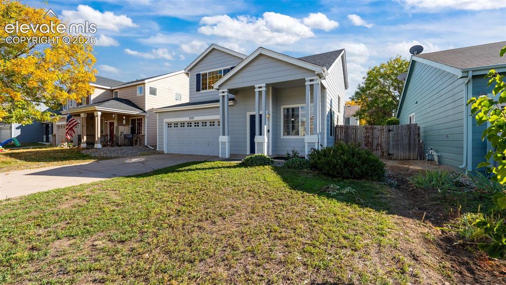 Image 3 of 26: Two-story exterior with light blue siding, a covered front porch with white