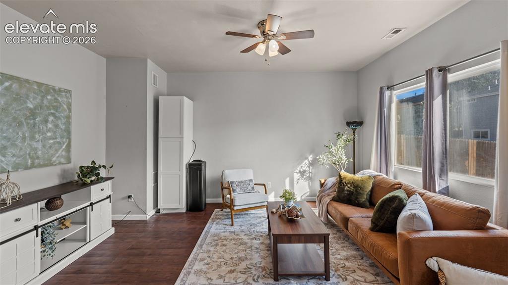 Image 7 of 26: Wood-finish flooring, ceiling fan, and multiple windows