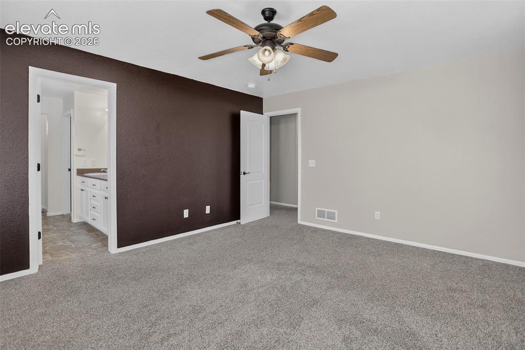 Image 17 of 46: Neutral wall finishes, textured accent wall, ceiling fan with light fixture