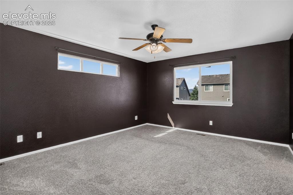 Image 19 of 46: Wall-to-wall carpeting, ceiling fan with light fixture, and multiple window
