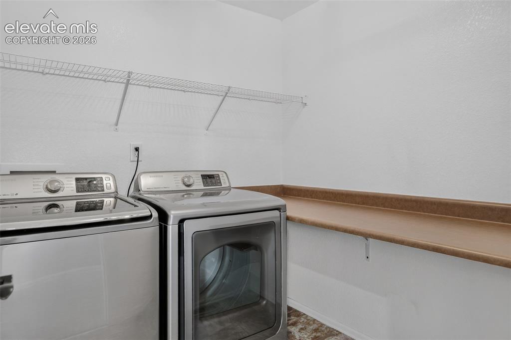 Image 28 of 46: Dedicated laundry space featuring a wire shelf, countertop, and white walls