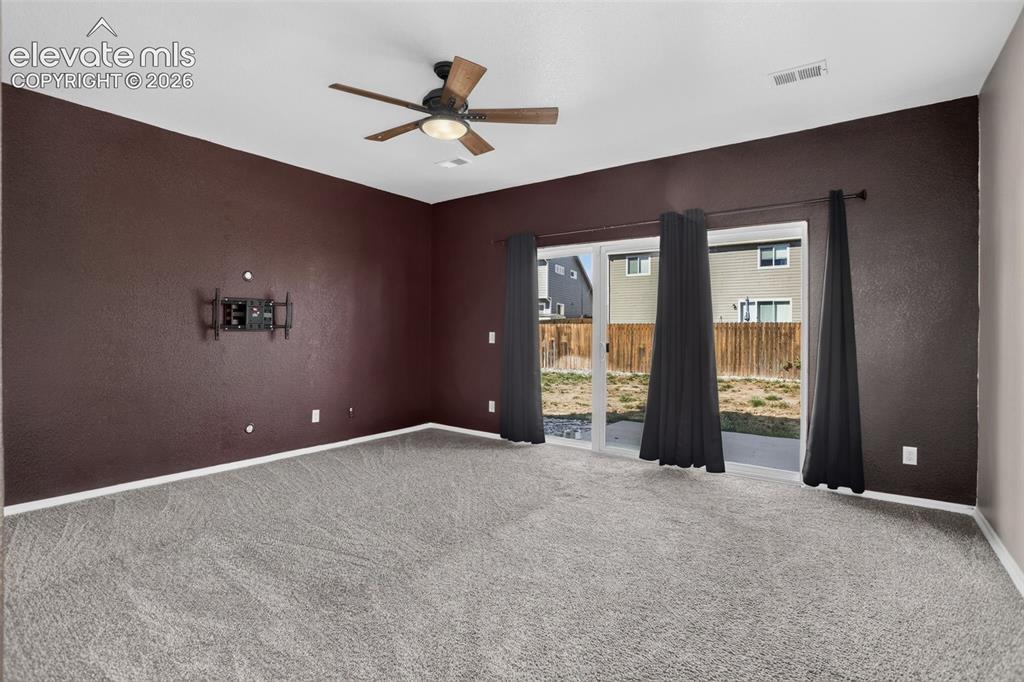 Image 29 of 46: Spacious room featuring neutral carpeting, deep burgundy accent walls, and 