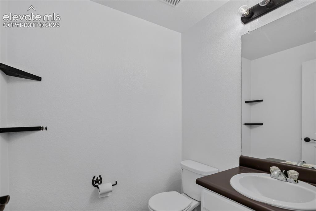 Image 32 of 46: Bathroom vanity with an integrated sink and a dark countertop