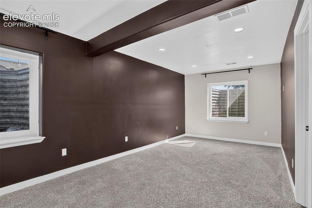Image 36 of 46: Recessed ceiling lighting, gray carpeting, dual windows, contrasting wall f