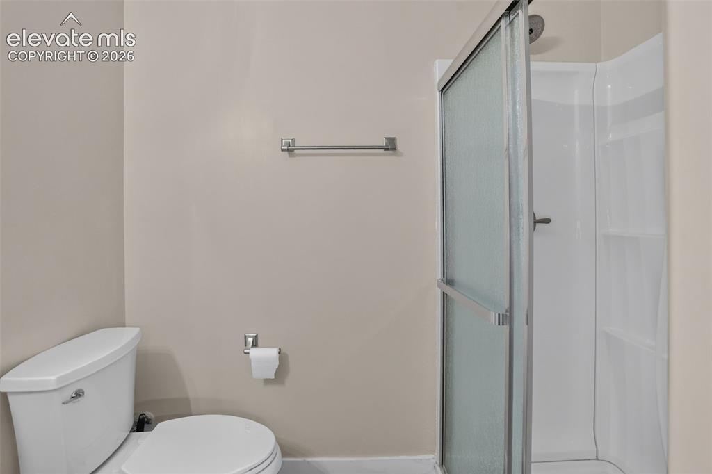 Image 38 of 46: Walk-in shower with a framed glass door, white shower surround, and integra