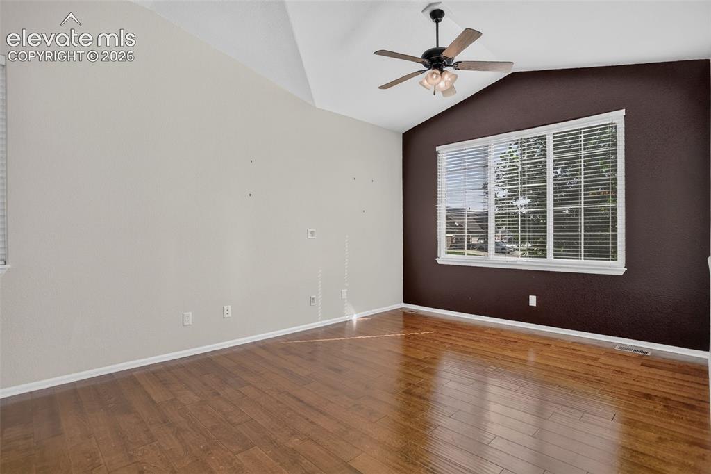 Image 4 of 46: Wood-finish flooring, vaulted ceiling, multi-pane window with blinds, and a