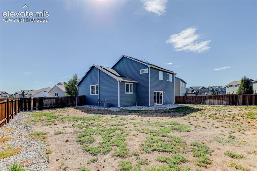 Image 42 of 46: Expansive backyard featuring a partial wood fence, gravel border, and a two